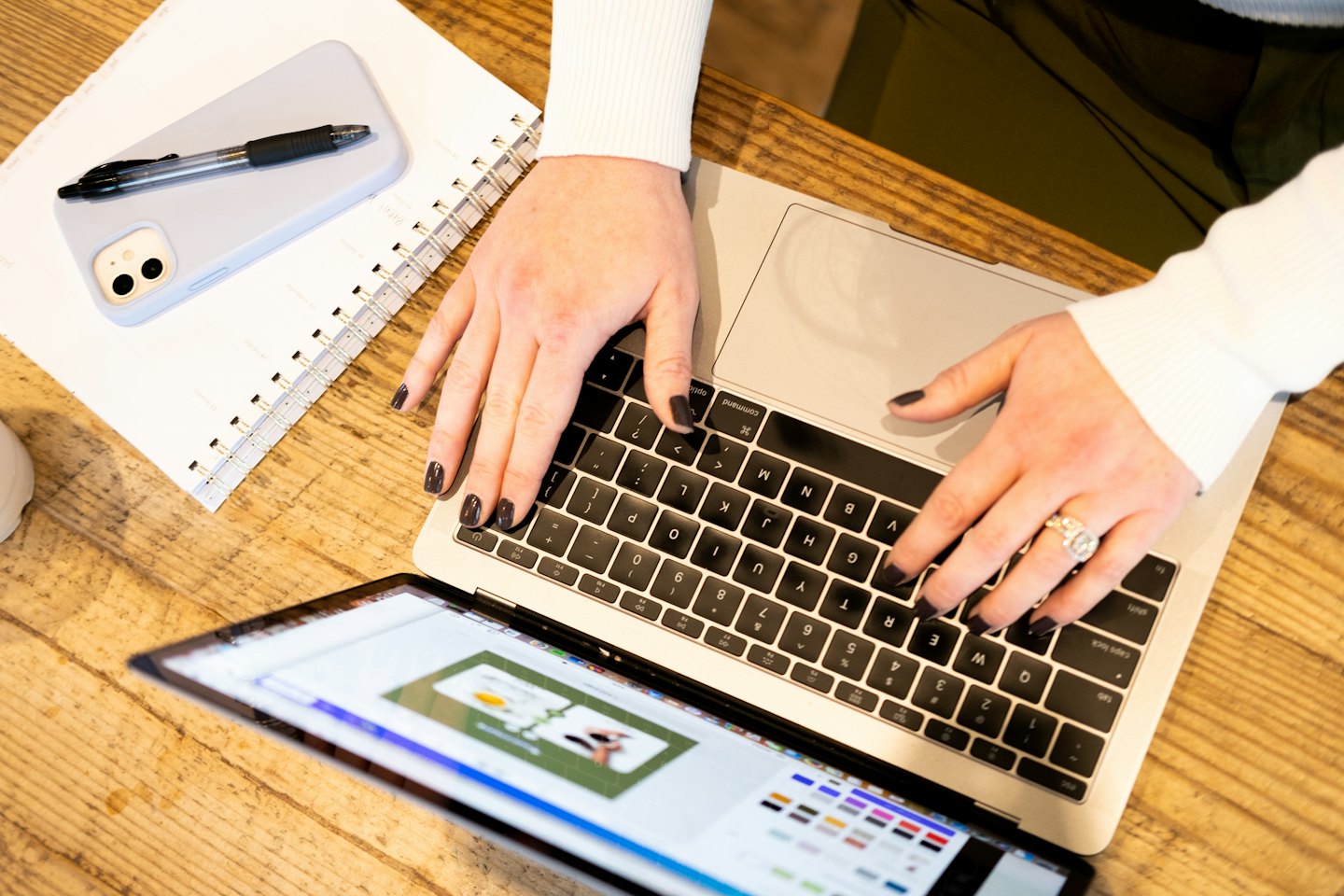 Persona digita su un laptop con un'interfaccia di design aperta.